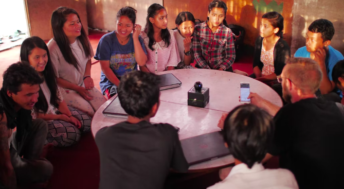 A group of people sitting around a table in Nepal.